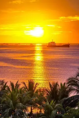 a sunset over the ocean with a ship in the water at Shore Residence D21 shortwalk MOA Balconypoolview in Manila