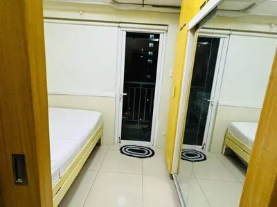 a small room with two beds and a balcony at SHELL RESIDENCE C23 Shortwalk MOA Balcony poolview in Manila