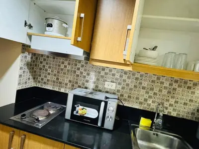 a kitchen with a counter top with a microwave at SHELL RESIDENCE C23 Shortwalk MOA Balcony poolview in Manila