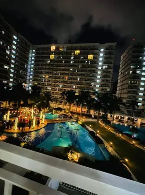 a view of a building with a pool at night at SHELL RESIDENCE C23 Shortwalk MOA Balcony poolview in Manila