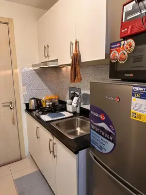 a kitchen with a sink and a stainless steel refrigerator at Makati SM Jazz Residence Staycation Condo with balcony in Manila