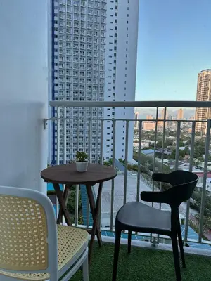 a table and chairs on a balcony with a view of a city at Makati SM Jazz Residence Staycation Condo with balcony in Manila