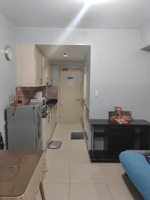 a kitchen with a refrigerator and a counter top at Sea Residences-Reisha in Manila