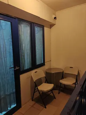a room with two chairs and a table and windows at Sea Residences-Reisha in Manila