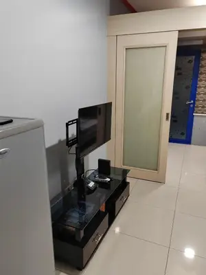 a living room with a television on a table at Sea Residences-Reisha in Manila