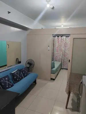 a living room with a blue couch in a room at Sea Residences-Reisha in Manila