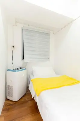 a white bedroom with a bed and a window at A2J Luxury 3BR BGC Loft Near Malls and Airport in Manila