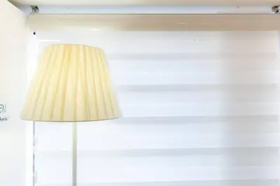 a lamp in a room with a white wall at A2J Luxury 3BR BGC Loft Near Malls and Airport in Manila