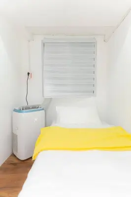 a white bedroom with a bed and a yellow blanket at A2J Luxury 3BR BGC Loft Near Malls and Airport in Manila