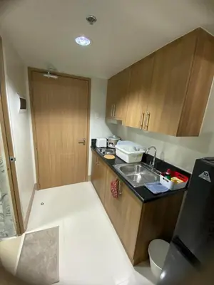 a small kitchen with a sink and wooden cabinets at Ella’s Condo@Shore3 T3 in Manila
