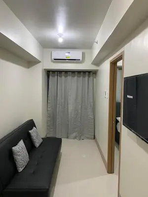 a living room with a black couch and a tv at Ella’s Condo@Shore3 T3 in Manila