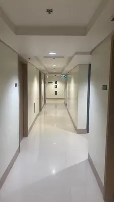 an empty hallway in a building with white floors at Ella’s Condo@Shore3 T3 in Manila