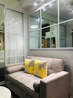 a living room with a couch and a mirror at Urbanview Oasis at Air Residences in Manila