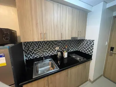a kitchen with a sink and a black counter top at MOA Staycation at Shore 2 in Manila