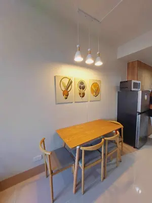a kitchen with a wooden table and chairs and a refrigerator at SHORE 3 RESIDENCES TOWER 2 in Manila