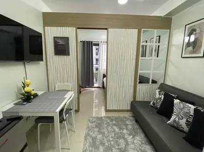 a living room with a couch and a table at Shore Residence D22 shortwalk MOA Balconypoolview in Manila