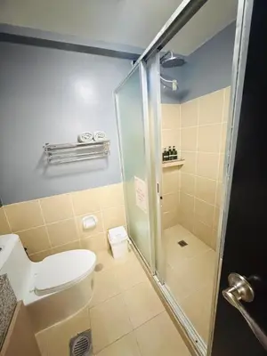 a bathroom with a toilet and a shower at Modern style 2BR Condo Good for 6 Packs Near NAIA in Manila