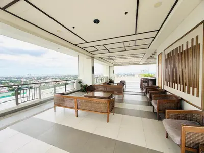 a restaurant with benches and a view of the city at Modern style 2BR Condo Good for 6 Packs Near NAIA in Manila