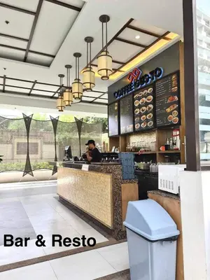 a man sitting at a bar in a restaurant at Modern style 2BR Condo Good for 6 Packs Near NAIA in Manila