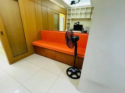 a room with an orange bench with a fan at SHELL RESIDENCE C22 Shortwalk MOA Balcony poolview in Manila