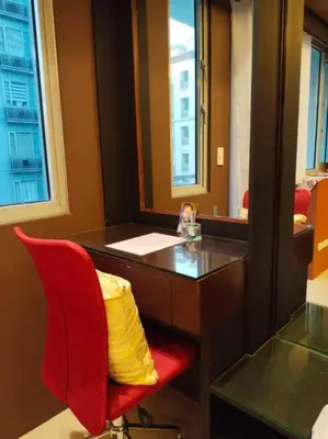 a desk with a red chair and a yellow pillow at Modern Condo Infront of NAIA T3 (Virluxe Suites) in Manila
