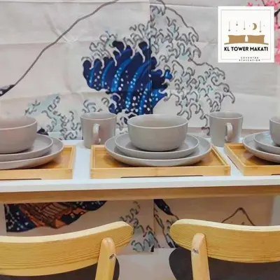 a table with cups and saucers on it at Muji KLTower Makati - Greenbelt - with Pool Access in Manila