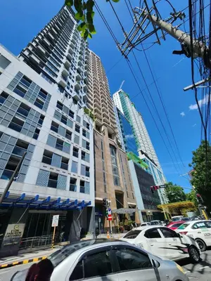 a tall building with cars parked in front of it at Muji KLTower Makati - Greenbelt - with Pool Access in Manila