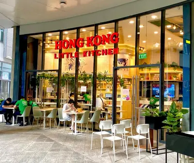 a person sitting at a table in front of a restaurant at Frost at Air Residences Makati in Manila