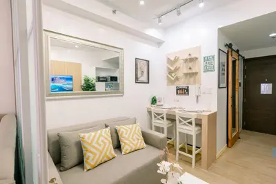 a living room with a couch and a table at Frost at Air Residences Makati in Manila