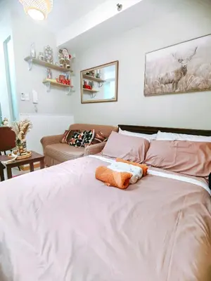 a bedroom with a large white bed and a couch at CAMP CJ Staycation A Cozy, Modern Studio near BGC & MRT Boni, Perfect for Relaxing City Getaways in Manila