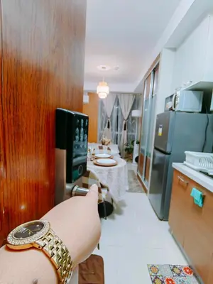 a person with a watch on their arm in a kitchen at CAMP CJ Staycation A Cozy, Modern Studio near BGC & MRT Boni, Perfect for Relaxing City Getaways in Manila