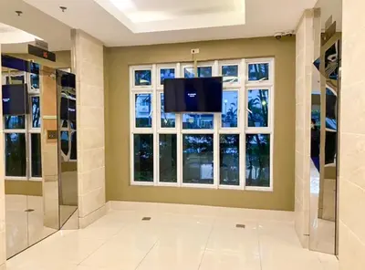 a living room with a flat screen tv and a window at Madison Place at Sea Residences powered by Cocotel in Manila