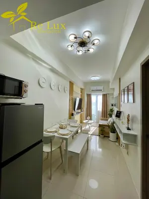 a kitchen and living room with a table and a refrigerator at Re Lux Staycation, NEAR NAIA in Manila