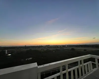 a sunset from the balcony of a house at Re Lux Staycation, NEAR NAIA in Manila