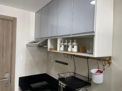 a kitchen with white cabinets and a shelf at Re Lux Staycation, NEAR NAIA in Manila