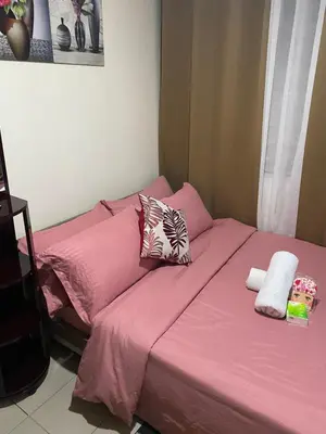 a pink bed with two pillows on top of it at Pierrecondotel in Manila