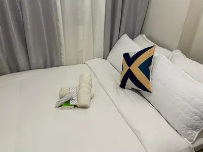 a white bed with towels and pillows on it at Pierrecondotel in Manila