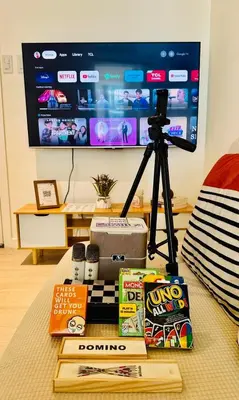 a table with a camera and books and a tv at Azure Urban Resort Residences Paranaque 2 Bedroom Unit in Manila