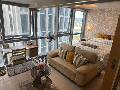 a bedroom with a bed and a couch and a table at Angelheaven EGPLR in Manila