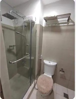 a bathroom with a toilet and a glass shower at Condotel-Shore 2 Residences MOA in Manila