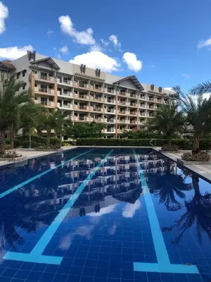 a large swimming pool in front of a large building at Family Suite w/ Centralized AC nr Ayala Mall Feliz in Manila