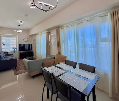 a living room with a dining table and a couch at Cozy Staycation Condo for Family in Ermita in Manila