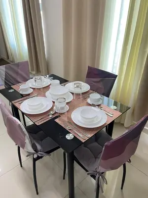 a black table with plates and glasses on it at Cozy Staycation Condo for Family in Ermita in Manila
