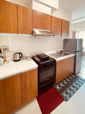 a small kitchen with a stove and a sink at Cozy Staycation Condo for Family in Ermita in Manila