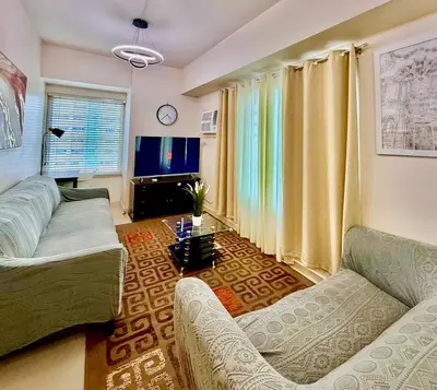 a living room with a couch and a table at Cozy Staycation Condo for Family in Ermita in Manila