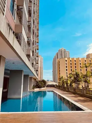 a swimming pool in the middle of a building with tall buildings at Modern Condo near St Lukes and US Embassy in Ermita Manila in Manila