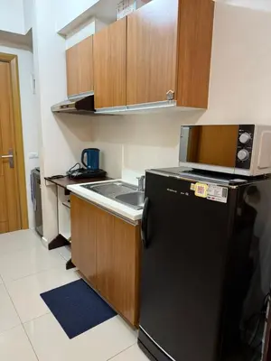 a kitchen with a black refrigerator and a sink at Modern Condo near St Lukes and US Embassy in Ermita Manila in Manila