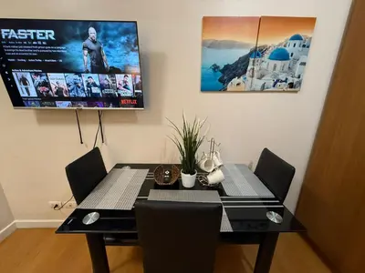 a dining room table with chairs and a movie poster at Modern Condo near St Lukes and US Embassy in Ermita Manila in Manila