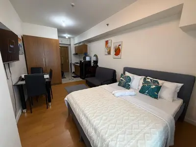 a bedroom with a bed and a desk in it at Modern Condo near St Lukes and US Embassy in Ermita Manila in Manila