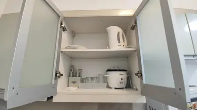 a kitchen cupboard with a appliance in it at 11B Tower 1 Viceroy Residences Mc Kinley Hill BGC in Manila